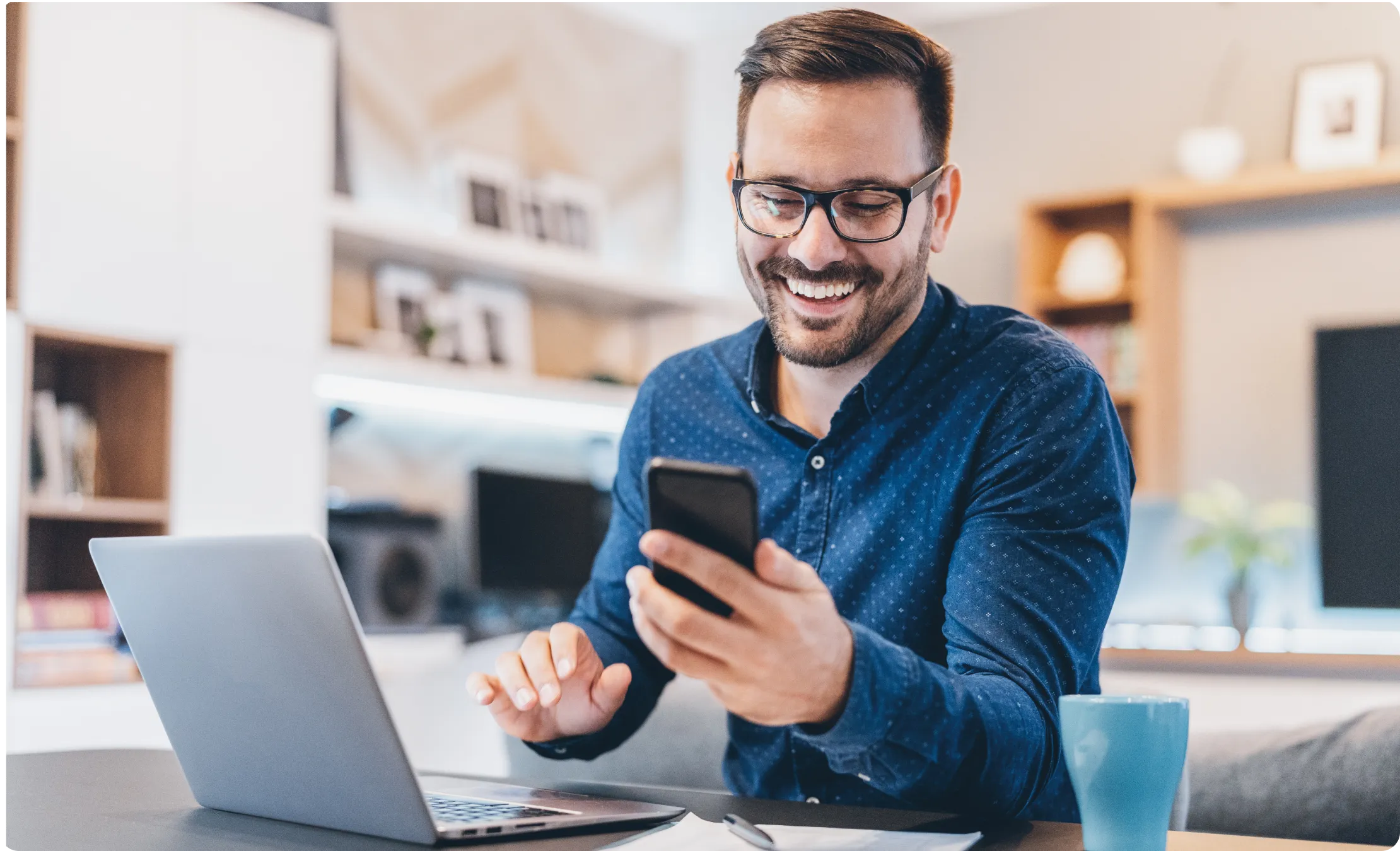 A man using Cellphone with laptop