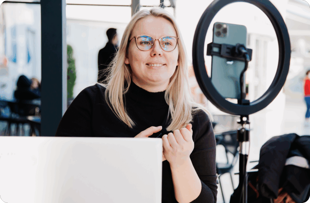 woman with glasses looking at phone on monopod